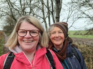 Two women smiling with trees in the background