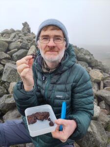 A man eating fungi dipped in chocolate